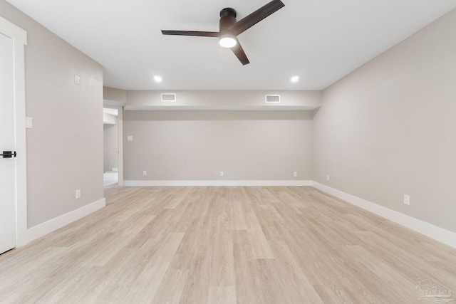 empty room with ceiling fan and light hardwood / wood-style flooring