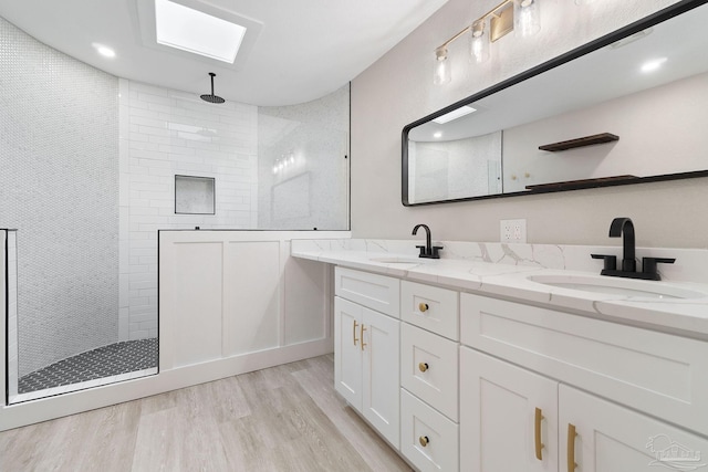 bathroom featuring tiled shower, vanity, and hardwood / wood-style flooring