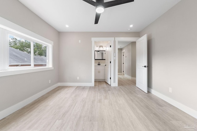 unfurnished bedroom featuring connected bathroom, light hardwood / wood-style flooring, ceiling fan, and sink