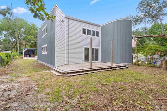 rear view of house featuring a lawn and a wooden deck