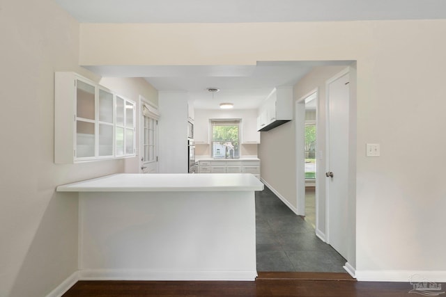 770 Connell Dr, Pensacola, FL 32503 - kitchen with white cabinets, a peninsula, light countertops, baseboards, and oven
