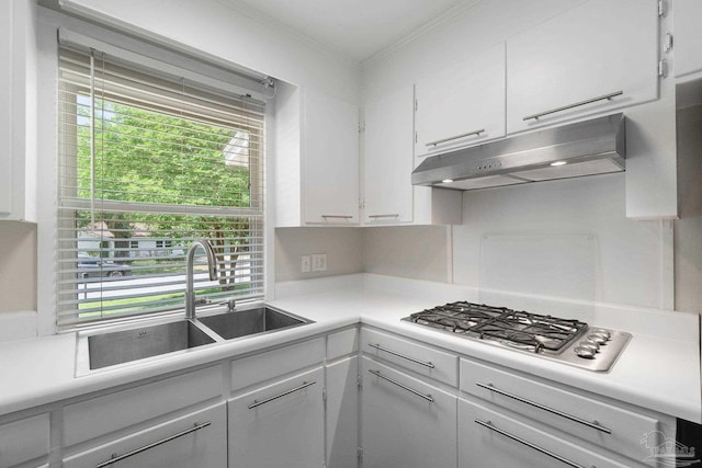 770 Connell Dr, Pensacola, FL 32503 - kitchen featuring under cabinet range hood, a sink, stainless steel gas stovetop, ornamental molding, and white cabinets