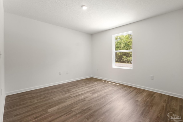 1113 Paulding Ave, Pensacola, FL 32507 - spare room featuring dark wood finished floors, baseboards, and a textured ceiling