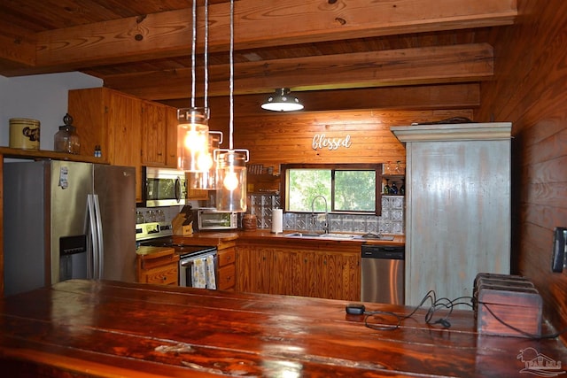 kitchen featuring sink, decorative light fixtures, wooden walls, wood ceiling, and appliances with stainless steel finishes