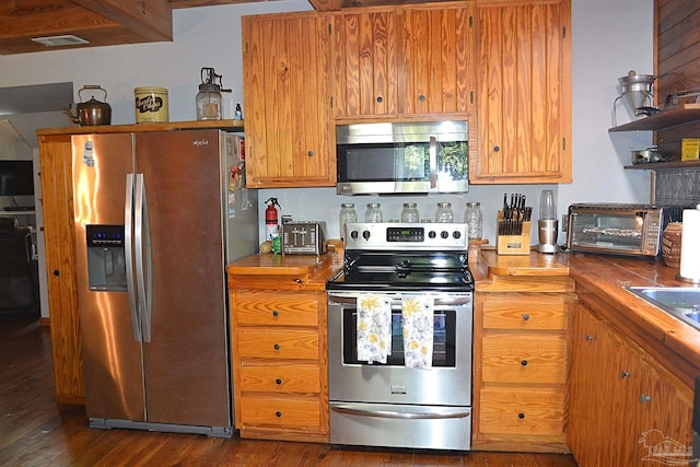 kitchen with sink, dark wood-type flooring, and appliances with stainless steel finishes