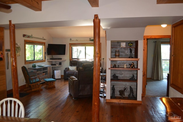 living room featuring vaulted ceiling with beams and dark wood-type flooring