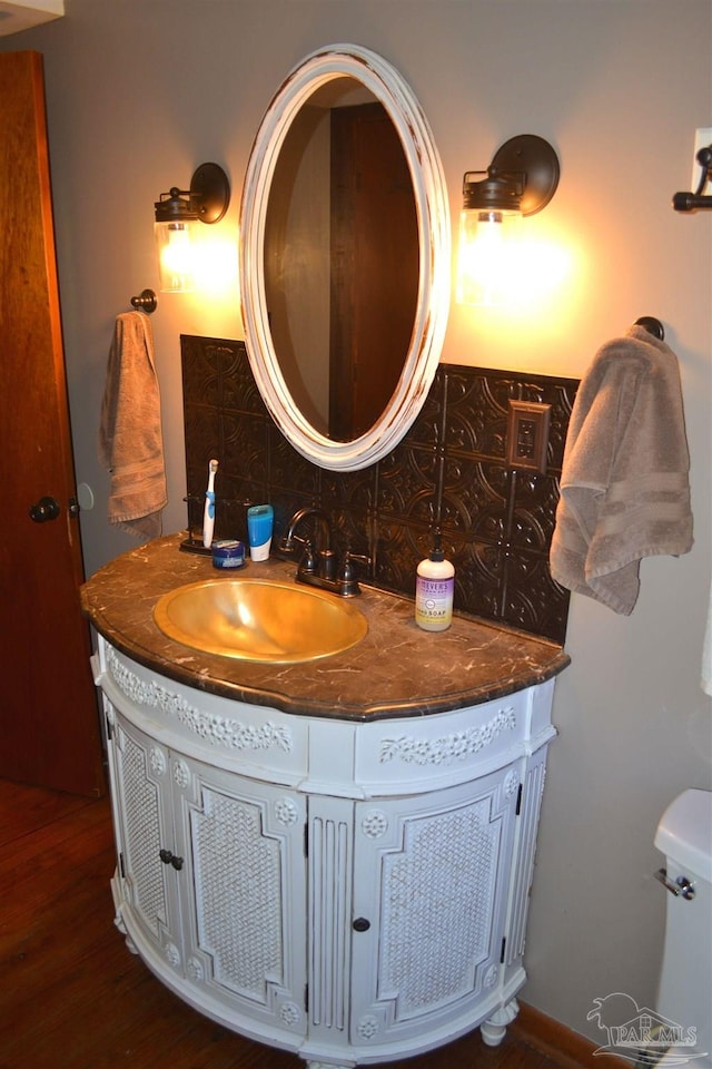 bathroom with tasteful backsplash, vanity, and hardwood / wood-style flooring