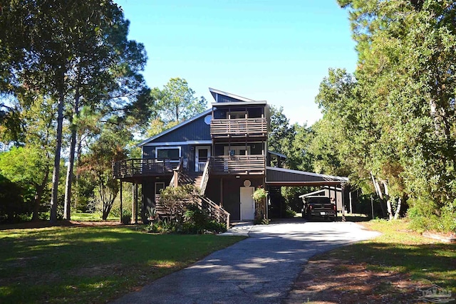 view of front of home with a front yard, a carport, and a wooden deck