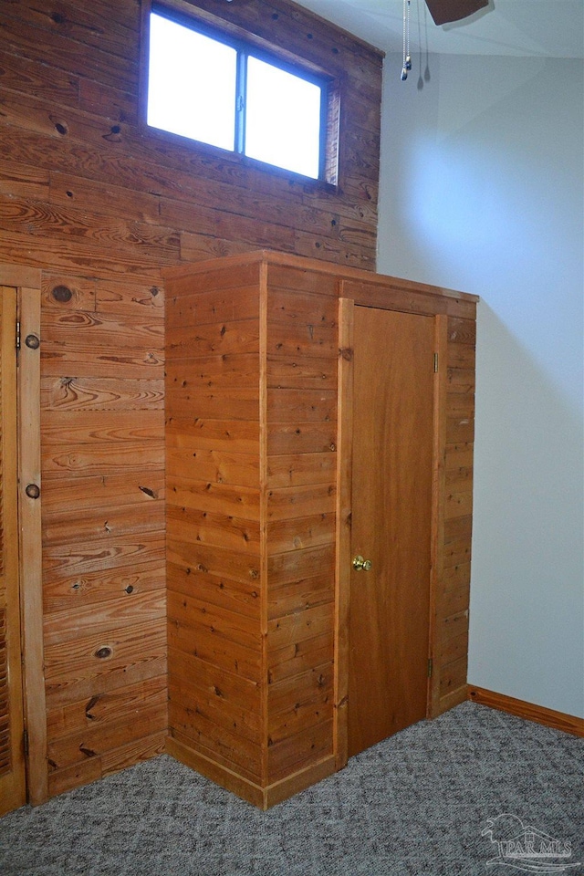 interior space with carpet flooring and wooden walls