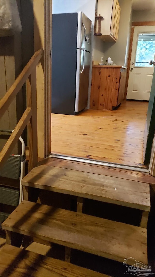 interior space featuring stainless steel fridge and light hardwood / wood-style floors