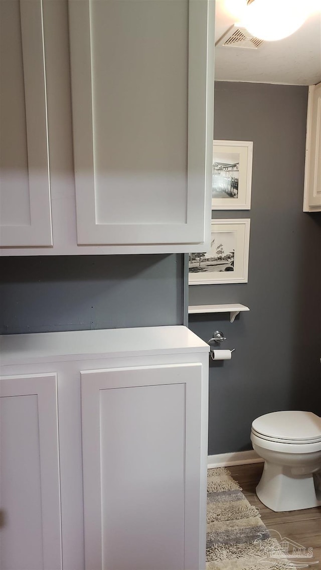 bathroom featuring wood-type flooring and toilet