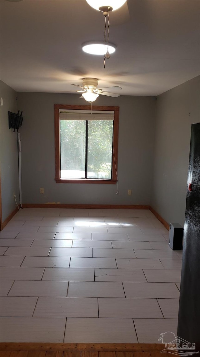 spare room featuring ceiling fan and light tile patterned flooring