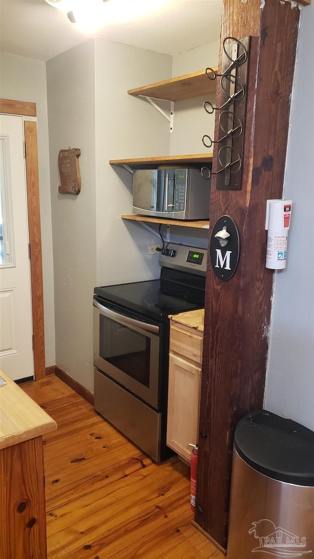 kitchen with light hardwood / wood-style flooring and appliances with stainless steel finishes