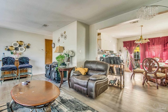 living room featuring a notable chandelier and light hardwood / wood-style floors