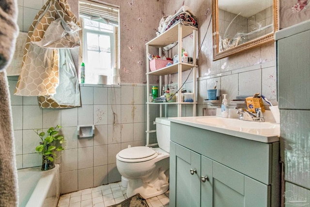 bathroom featuring tile patterned flooring, vanity, toilet, and tile walls