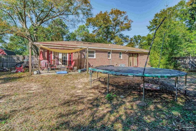 rear view of house with a patio and a trampoline