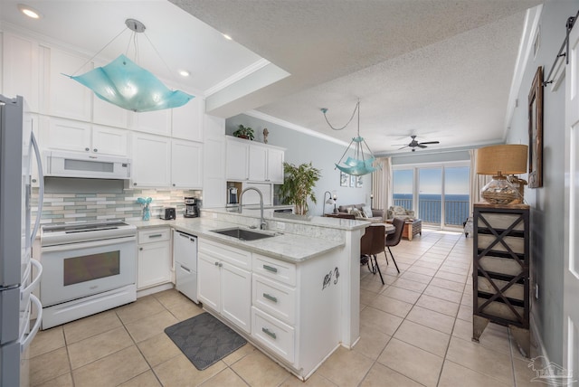 kitchen featuring kitchen peninsula, white cabinetry, sink, and white appliances