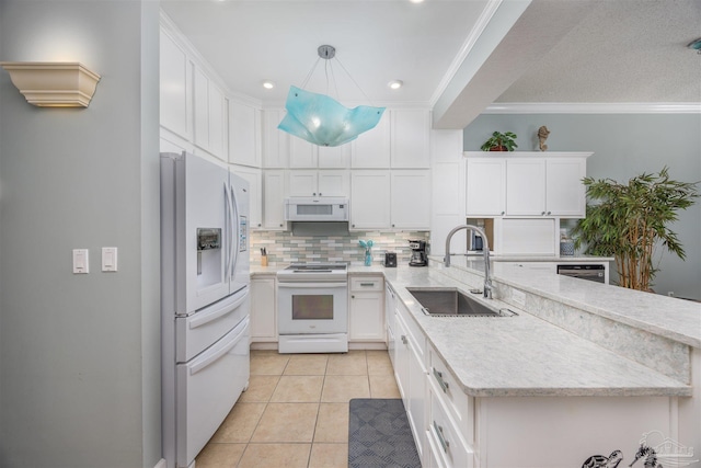 kitchen featuring sink, white cabinets, decorative light fixtures, and white appliances