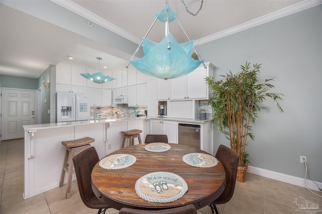 dining room with light tile patterned floors, a textured ceiling, and ornamental molding