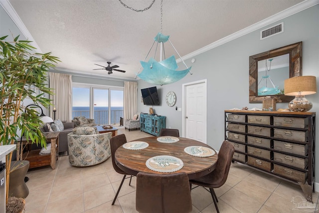 dining area with crown molding, light tile patterned flooring, a textured ceiling, and ceiling fan