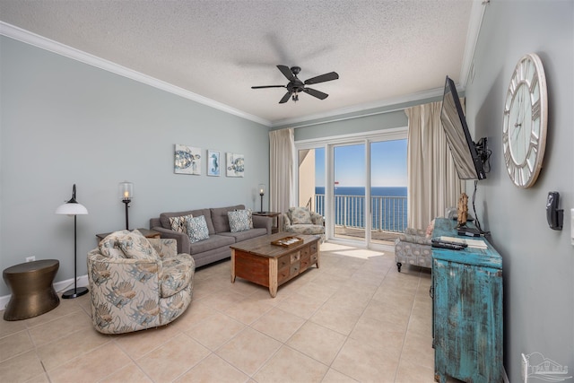 living room with ceiling fan, light tile patterned flooring, ornamental molding, and a textured ceiling