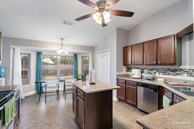 kitchen featuring light stone counters, a center island, pendant lighting, stainless steel appliances, and backsplash