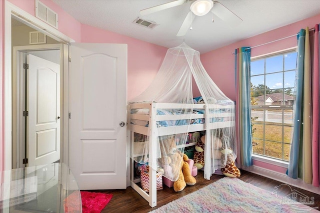 bedroom featuring dark wood-type flooring, ceiling fan, and multiple windows