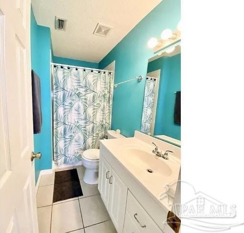 bathroom featuring tile patterned flooring, toilet, vanity, and a shower with curtain