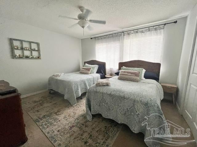 carpeted bedroom with a textured ceiling and ceiling fan