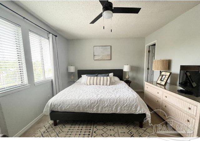 bedroom with a textured ceiling and ceiling fan