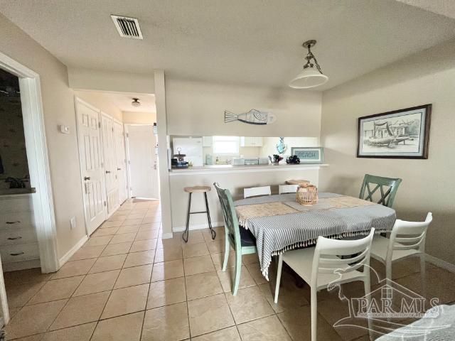 tiled dining area with a textured ceiling