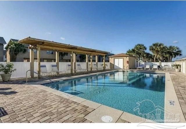 view of swimming pool featuring an outdoor structure and a patio area