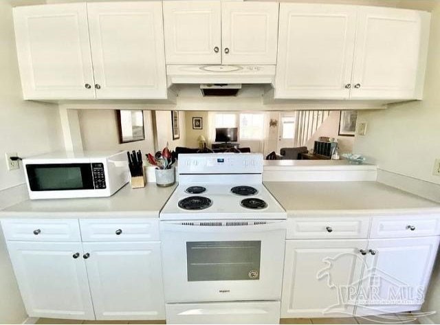 kitchen featuring white cabinetry and white appliances