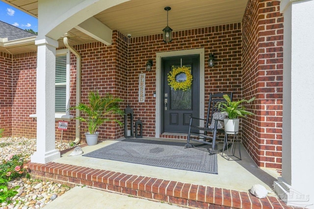 property entrance with brick siding and covered porch