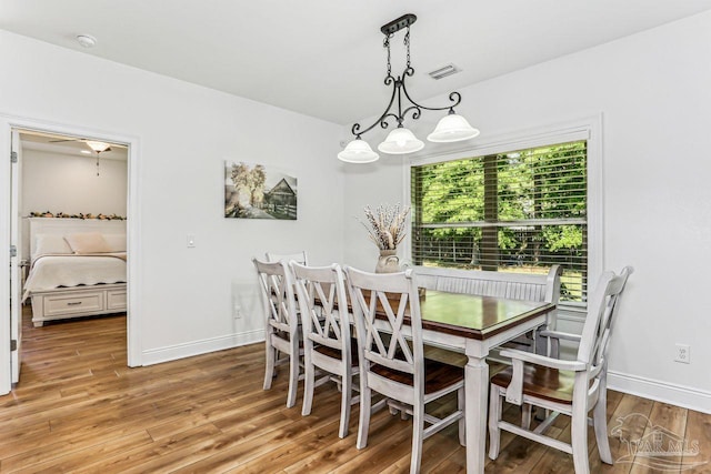 dining room featuring light wood-type flooring, baseboards, and visible vents