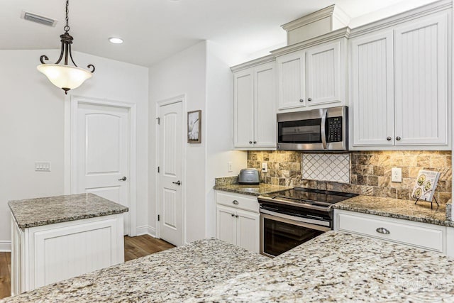 kitchen featuring backsplash, visible vents, dark wood-style floors, and appliances with stainless steel finishes