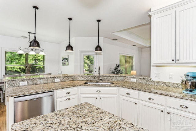 kitchen with white cabinets, plenty of natural light, stainless steel dishwasher, and a sink