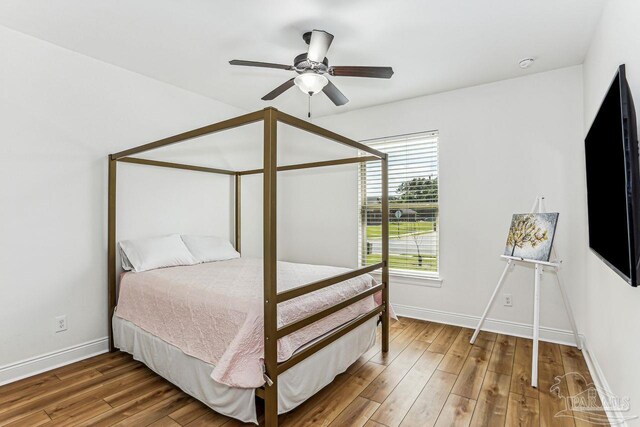 bedroom featuring wood finished floors, a ceiling fan, and baseboards