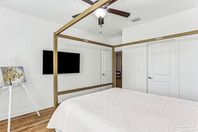bedroom with a closet, visible vents, light wood finished floors, and a ceiling fan