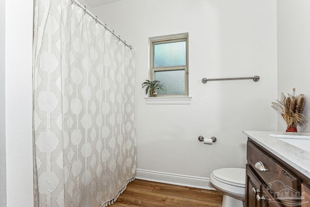 full bath featuring wood finished floors, toilet, vanity, a shower with curtain, and baseboards