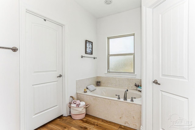 bathroom with a bath and wood finished floors