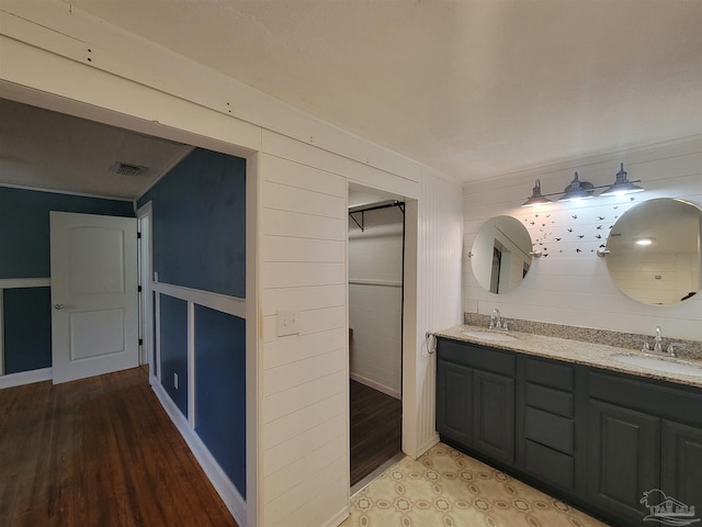5927 Mitchell Ln, Pensacola, FL 32526 - full bath featuring double vanity, wood finished floors, visible vents, and a sink