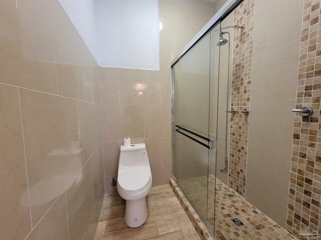 5927 Mitchell Ln, Pensacola, FL 32526 - bathroom featuring a shower stall, toilet, and tile walls