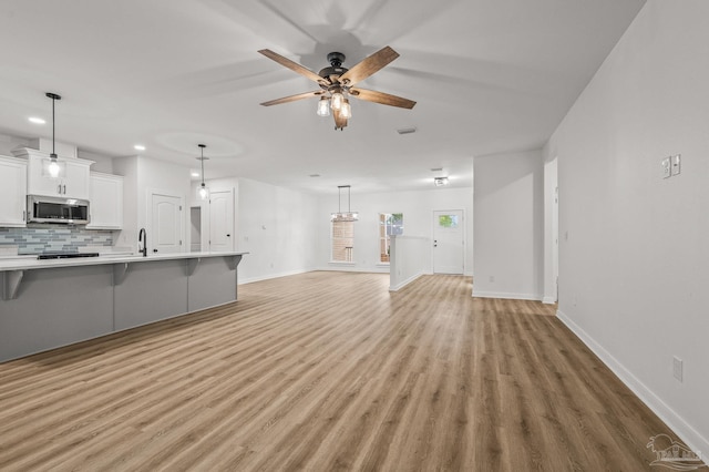 1192 Adrian Way, Milton, FL 32583 - unfurnished living room with a sink, light wood-type flooring, baseboards, recessed lighting, and ceiling fan