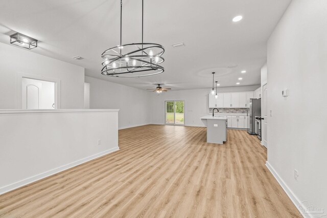 1192 Adrian Way, Milton, FL 32583 - unfurnished living room featuring ceiling fan, recessed lighting, a sink, light wood finished floors, and a chandelier