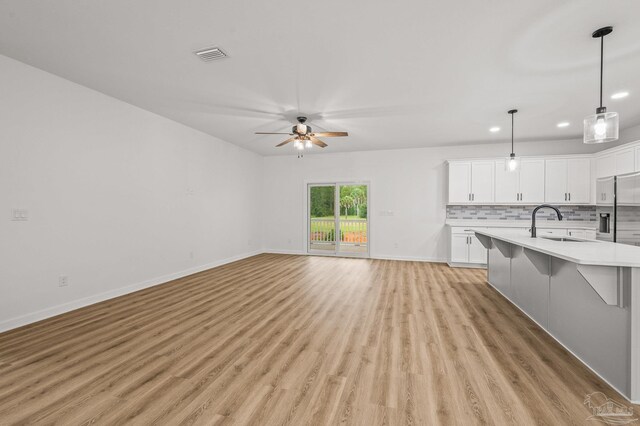 1192 Adrian Way, Milton, FL 32583 - unfurnished living room featuring light wood-type flooring, a ceiling fan, recessed lighting, baseboards, and a sink
