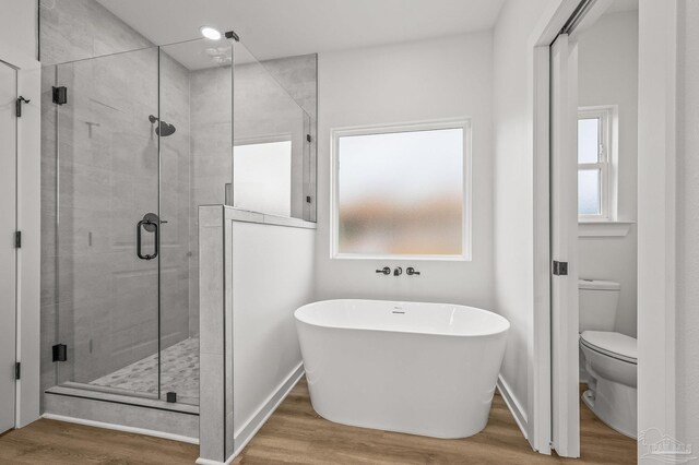 1192 Adrian Way, Milton, FL 32583 - bathroom featuring wood finished floors, a freestanding tub, a stall shower, and toilet