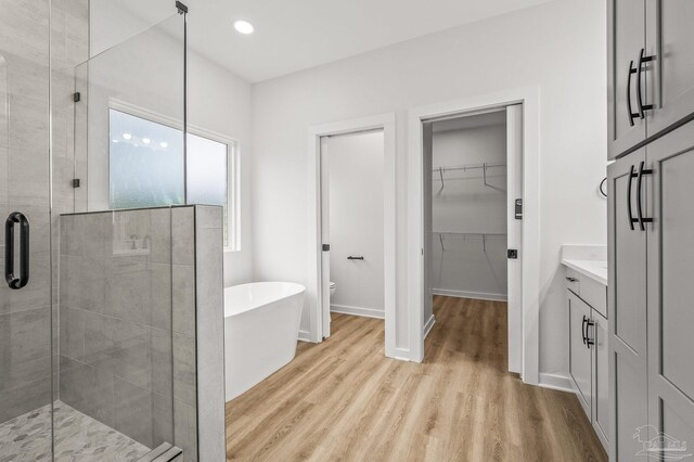 1192 Adrian Way, Milton, FL 32583 - full bath featuring a shower stall, a freestanding tub, wood finished floors, a spacious closet, and recessed lighting