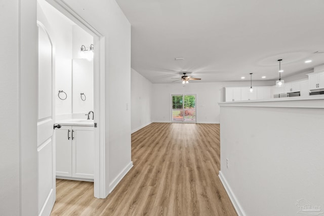 1192 Adrian Way, Milton, FL 32583 - hall featuring light wood-type flooring, baseboards, a sink, recessed lighting, and arched walkways