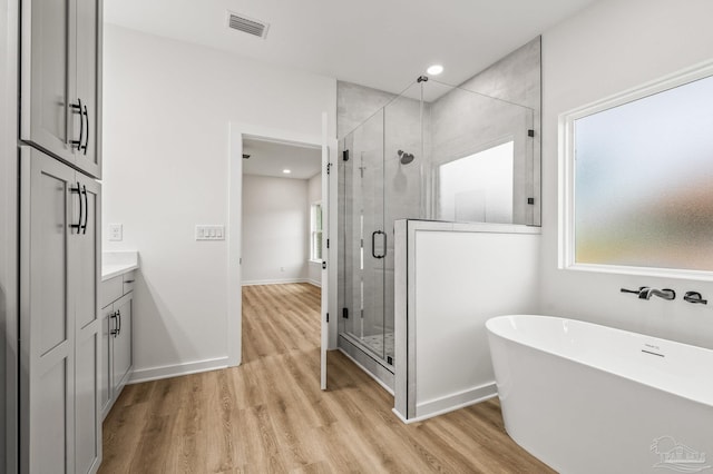 1192 Adrian Way, Milton, FL 32583 - full bath featuring a freestanding tub, a shower stall, wood finished floors, vanity, and recessed lighting